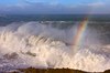 Regenbogen über brechenden Wellen
