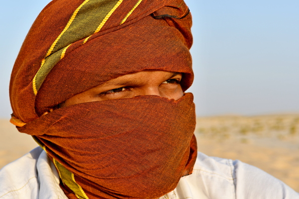 Arabic Indian Man in desert: Arabic Indian man in desert with head scarf a traditional culture that is going on for hundreds and hundreds of years in the Arabic countries and in Saudi Arabia . Photos in desert on the desert hill with sand only in the area and everywhere in the backgr