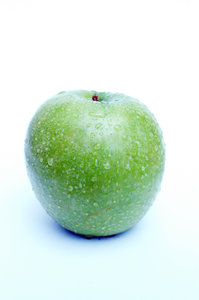 Manzana verde con gotas de agua.