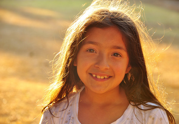 Young girl Smiling at camera: Young girl at the park, smiling at camera, with sunlight shining on hair