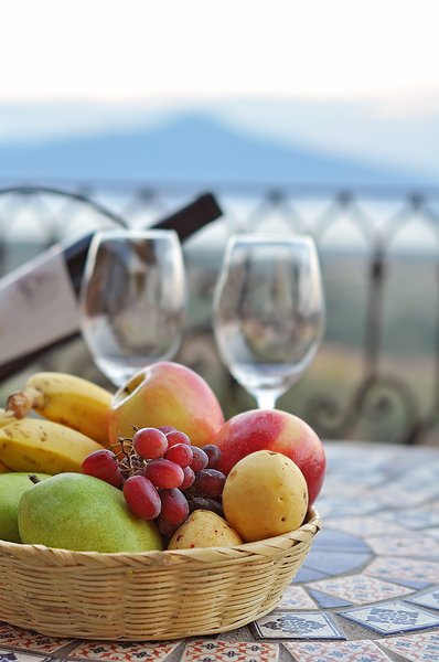 Fruit Basket: Fruit basket on a table, mountain and lake in the background, out of focus