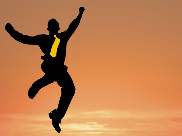 Business Leap: Business man leaping against a sunset sky