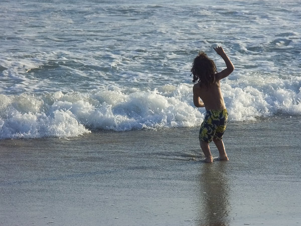Child playing in the waves