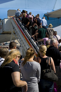 Flight_1: People walking up the stairs to an airplane