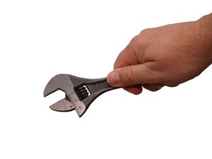 Handheld wrench: Hand holding a wrench