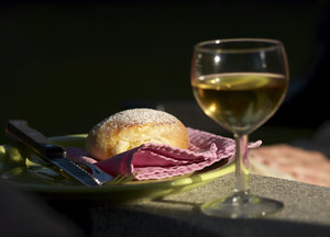 Piece of bread: Piece of baked bread with a blurred glass of white wine