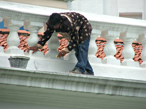 rooftop whitewash: workman whitewashing church rooftop balustrade