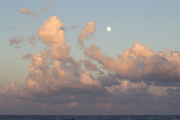 Full moon at dawn: The full moon and clouds at dawn over the Mediterranean.