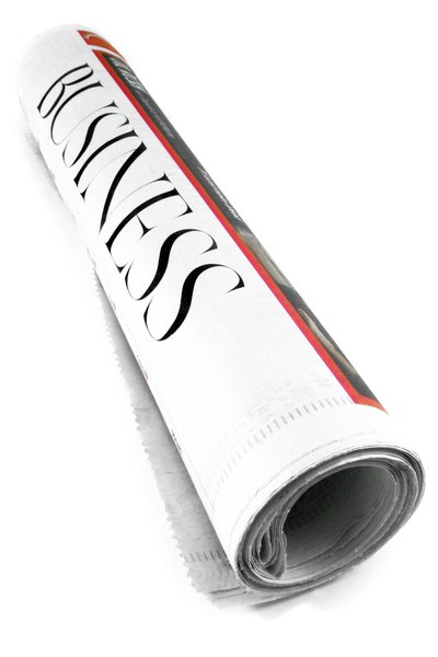 Business Newspaper Section: Rolled up newspaper isolated on a white background, with the headline BUSINESS prominently displayed on its cover.