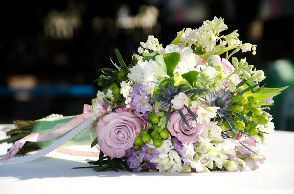 Bridal Bouquet: Lavender and white bridal bouquet on wedding reception table