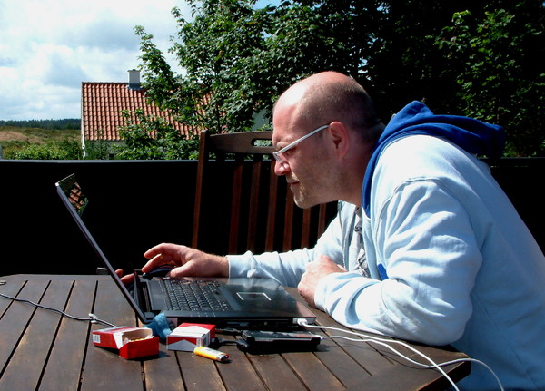Man at work: Working with a laptop outside on a terrace, Homeoffice