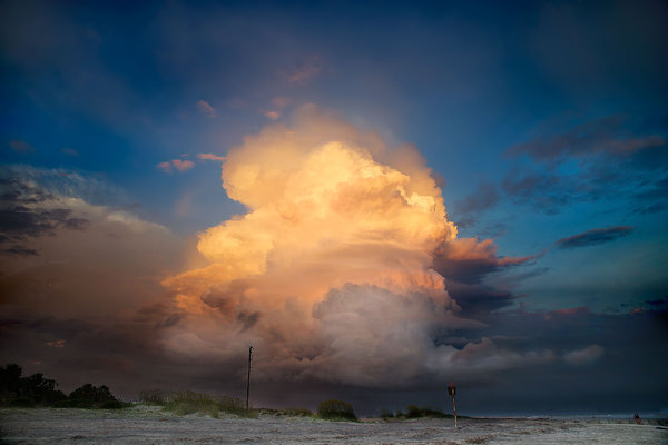 Storm cloud on fire: Cumulus cloud at the edge of an late evening storm above the beach of an island. The light was failing