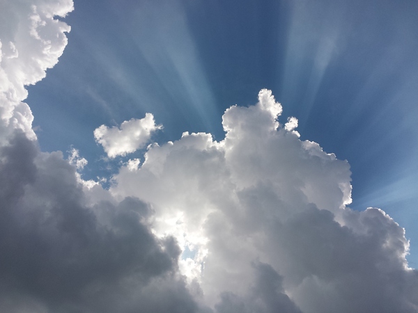 Sun & Clouds: Sunrays illuminate the blue sky behind some impressive clouds