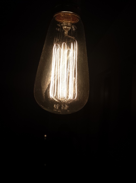 old light bulb: Low intensity old light bulb in dark background