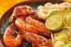 Plate of shrimp mexican food: Plate of mexican food: shrimp, rice, avocado, lemon and lettuce on a hand-made plate.
