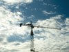 crane: Crane at a construction site, seen against a dark blue clouded sky.