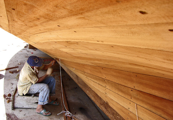 Caulking: An old artisan shipwright at work on a Bongo (medium sized fishing boat used locally. Typical Measurents: LOA: 14 Mts. Beam: 4.4 Mts. Inboard diesel engine)  in Punta de Palmas, Oriental coast of the Maracaibo lake, Venezuela.