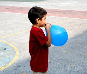 blowing illusions: A child plays seriously with his fragile globe.