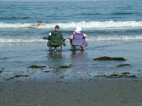 Retired and relaxing: An older couple relaxes on the beach in New Hampshire.