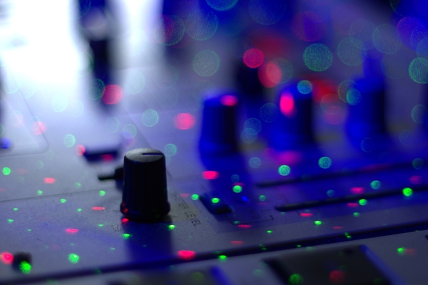 DJ mixer: DJ mixer with spots from laser light. Narrow depth of field.