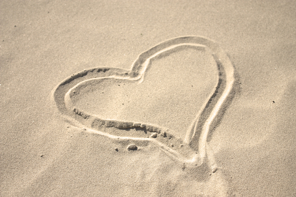 Sand heart 2: A sand heart drawn in the sand on the beach