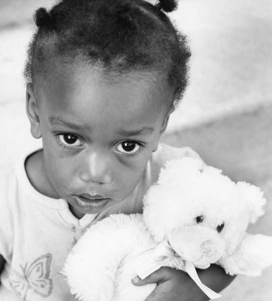 Child with Teddy Bear: Young child clutching on to cherished posession