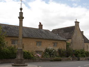 Village scene: Sandstone houses and a memorial in a village in Somerset, England.