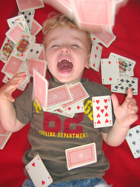 Playing cards: little boy throwing playing cards in the air.