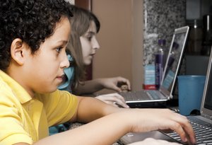 Online kids: A boy and a girl plugged on the web