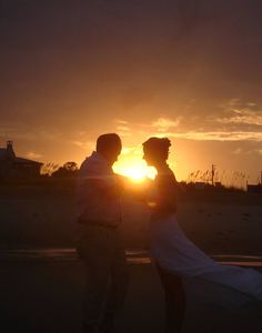 Sunset Love: A couple at sunset. The man is proposing to the lady.