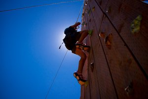 Rock Wall Climbing: 7 year old girl climbing a rock wall, silhouetted by the sun