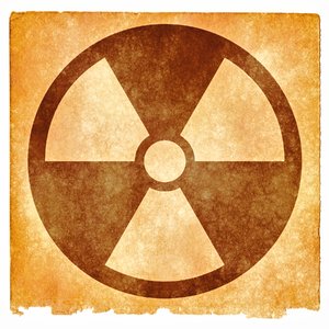 Nuclear Grunge Sign: Grunge textured nuclear symbol on vintage paper, with sepia toning for a more aged feel.