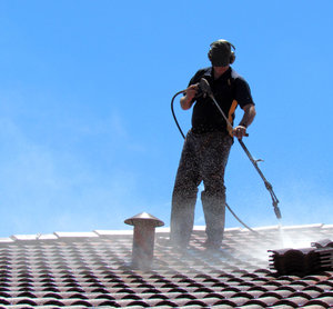 roof restoration3: workman cleaning roof tiles for restoration