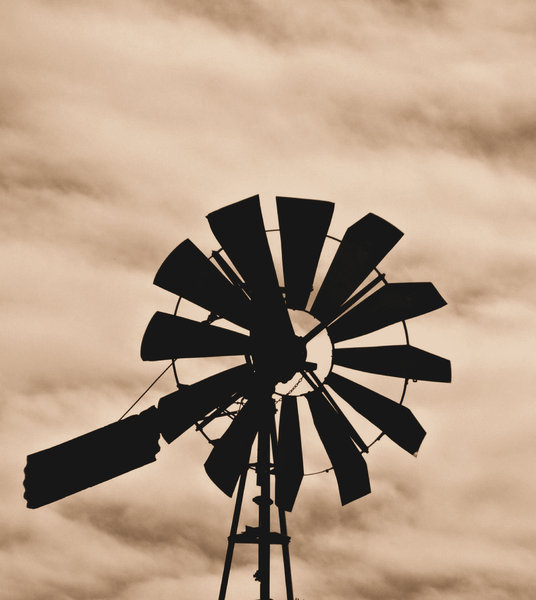 old windmill silhouette: sepia image of old farm windmill silhouette
