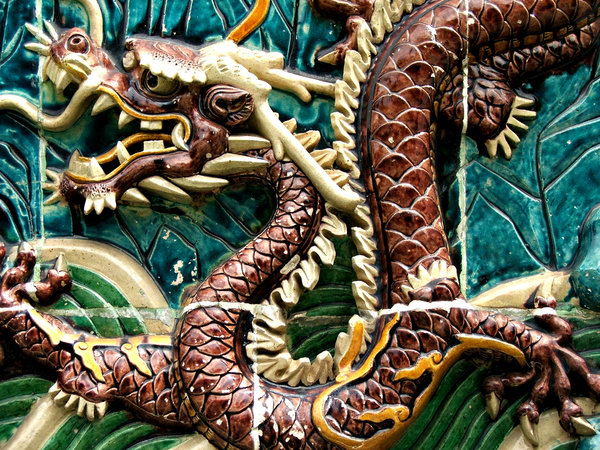 dragon closeup: close-up of dragon decorated wall alongside public footpath