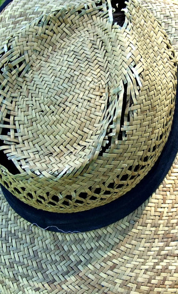 frayed hat: frayed crown of old straw hat