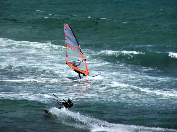 sailing through the surf: surf glider - kite surfer and wind surfer passing each other in the water
