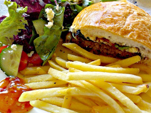 Burger and fries: Close up of burger and french fries (chips) with salad and sauce