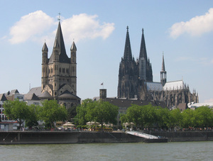 Cologne skyline: Famous Cologne (Germany) skyline with Cathedral (right) and church Groß St. Martin (left) at the riverside; picture taken from a ship on the Rhine river.