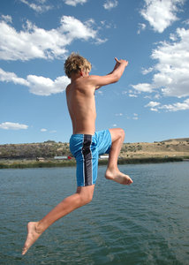 The Leap: Boy jumping from a boat into a lake.