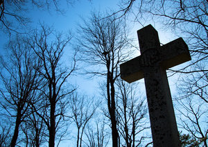 Lift High the Cross: Cross in a cemetary in Wolfville, Nova Scotia, Canada behind an Anglican Church