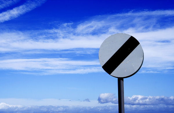 No Limits: Speed limits sign against cloudy blue sky.