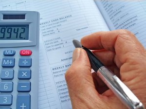 Business Accounts: Hand with a pen over an accounts book