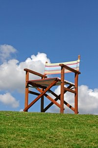 Canvas Garden Chair: Ordinary empty wooden framed garden chair against a blue sky